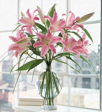 pink oriental lilies in fishbowl bottle vase